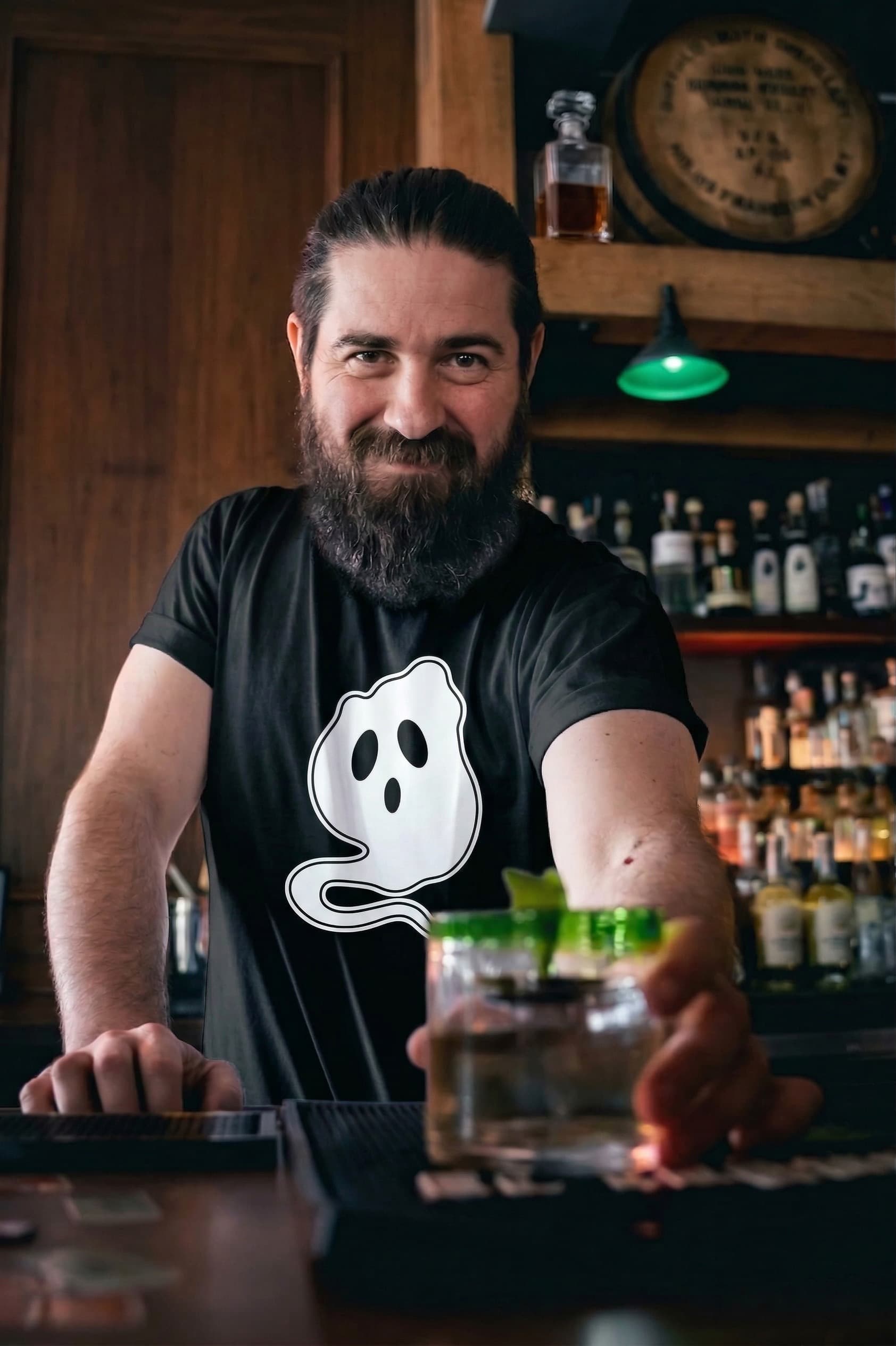Roberto Rivas serving a cocktail behind the bar